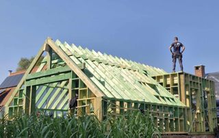 couvreur sur une toiture en construction