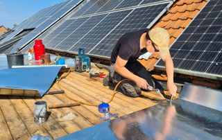 couvreur zingueur sur toit avec panneaux solaires