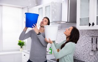 Couple qui récupère l'eau d'une fuite