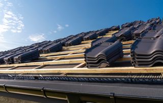 pose de tuiles en céramique sur une toiture en construction