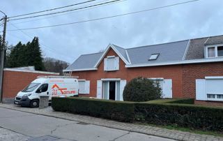 camionnette DJ Toiture garée devant une maison