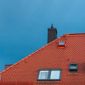 Vue sur une toiture avec une fenêtre de toit et une cheminée